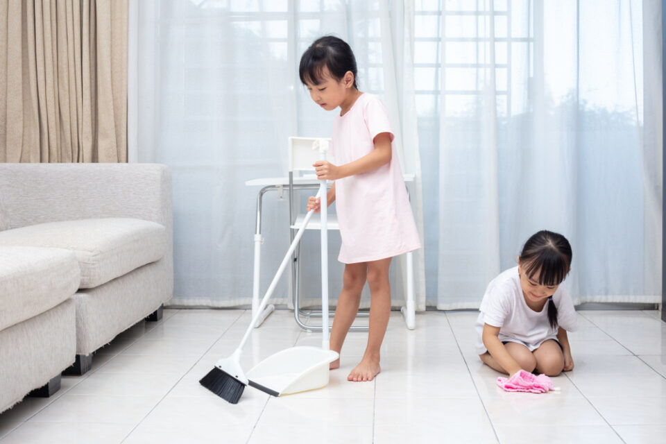 Two little girls sweeping and doing housework