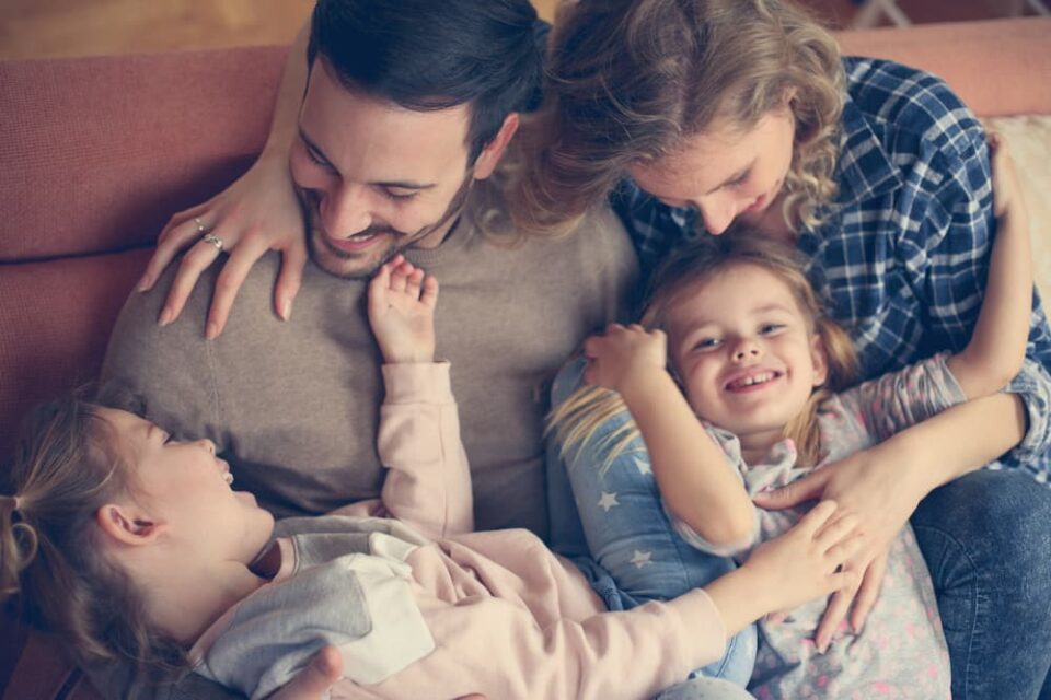 Two parents playing happily with children