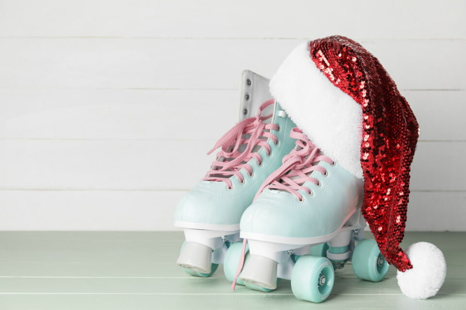 A sequined Santa hat sitting on a pair of light blue roller skates