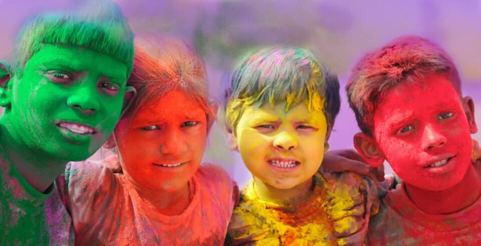 Four children with Holi powder on their faces