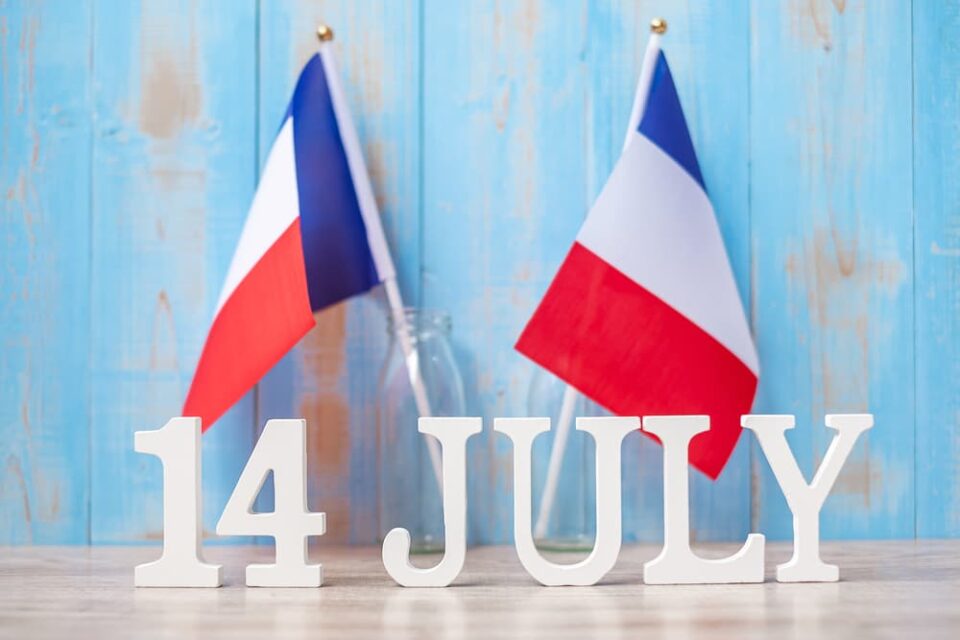Two French flags and wooden blocks reading 14 July