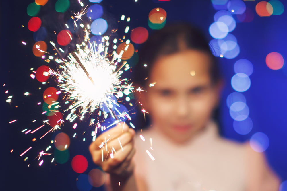 A young girl holding a sparkler