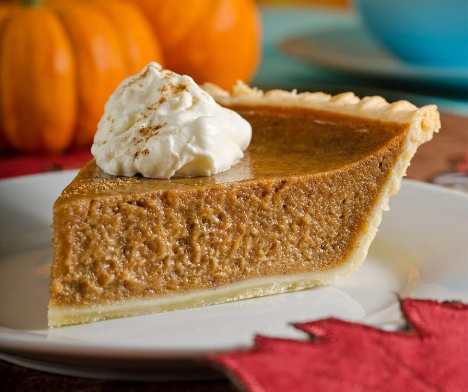 Pumpkin pie served with whipped cream on a plate