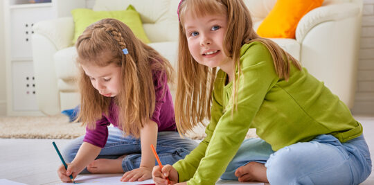 Girls coloring on floor