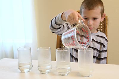 pour one fourth cup warm water into four glasses