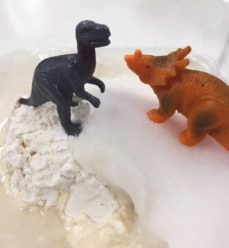 Toy dinosaurs on mound of salt and flour