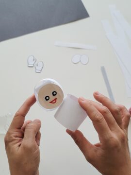 Person gluing paper astronaut together