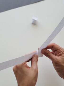Hands making an accordion fold on a strip of paper