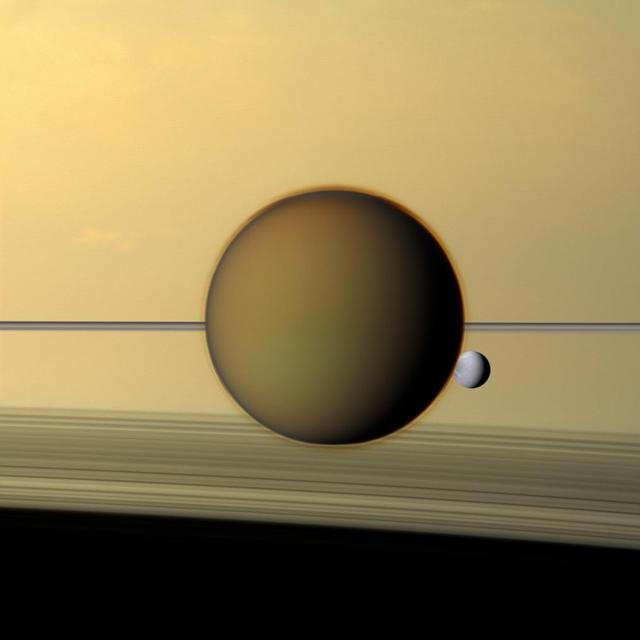 Saturn's moons Titan and Dione in orbit around it