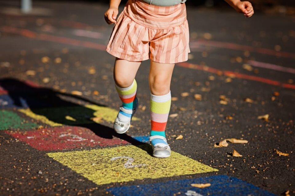 Child playing a fun hopscotch sidewalk chalk game