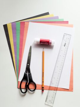 Supplies for a pop-up Halloween card: scissors, pencil, glue stick, ruler, construction paper