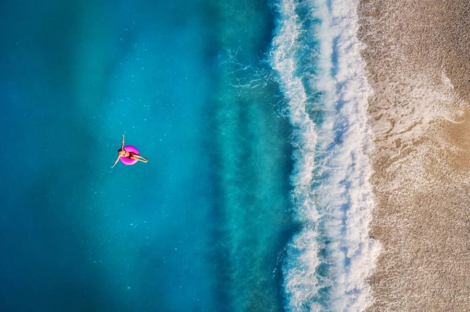 An-aerial-view-of-a-young-woman-on-a-pink-swim-ring-in-the-ocean