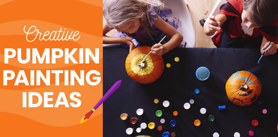 A view from above of kids painting pumpkins on a black table.
