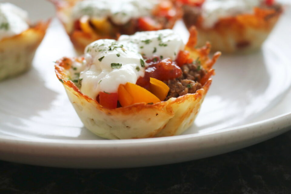 Taco cups with sour cream served on a plate