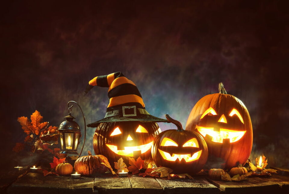 Three carved and lit Halloween pumpkins on a dark background