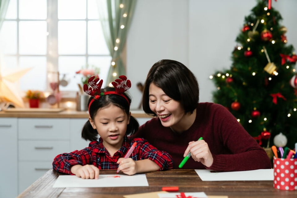 A mother and daughter making Christmas crafts together