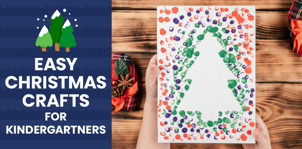 A child’s hands holding a fingerprint Christmas tree craft