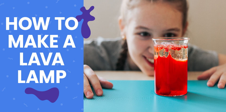 A girl smiles at a DIY lava lamp on a table