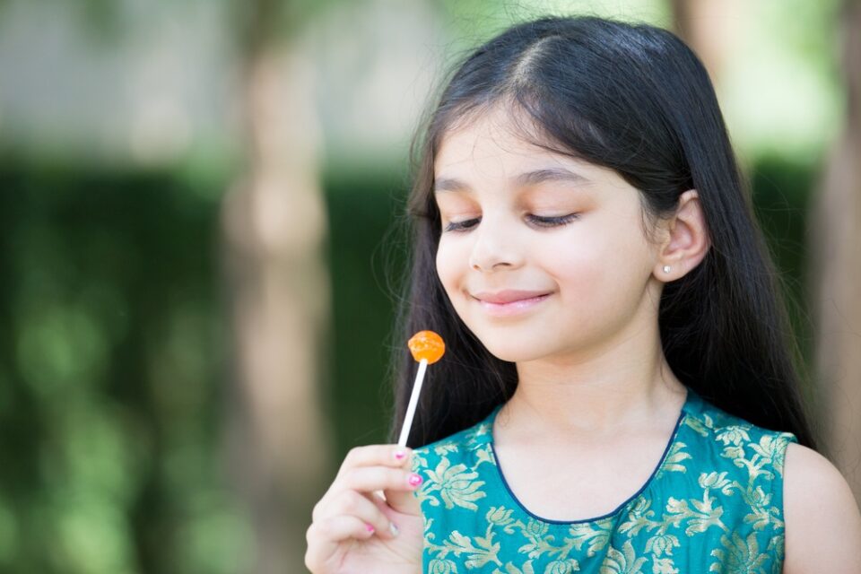 A young girl enjoying a lollipop.