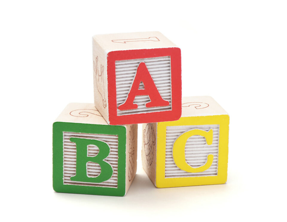 Three wooden alphabet blocks.