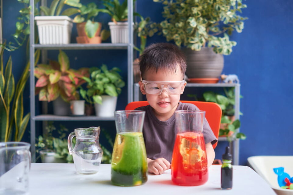 A young boy looking at two DIY lava lamps.
