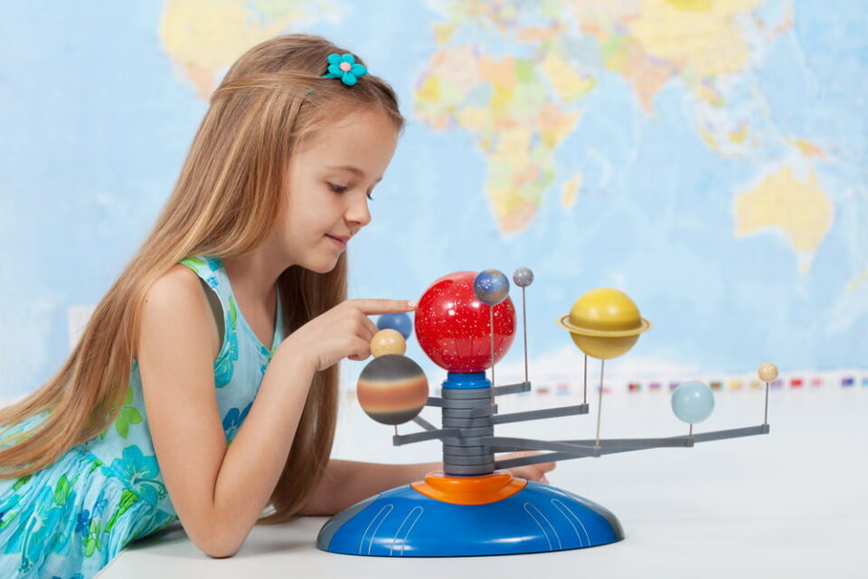 A-girl-studying-a-model-of-the-solar-system