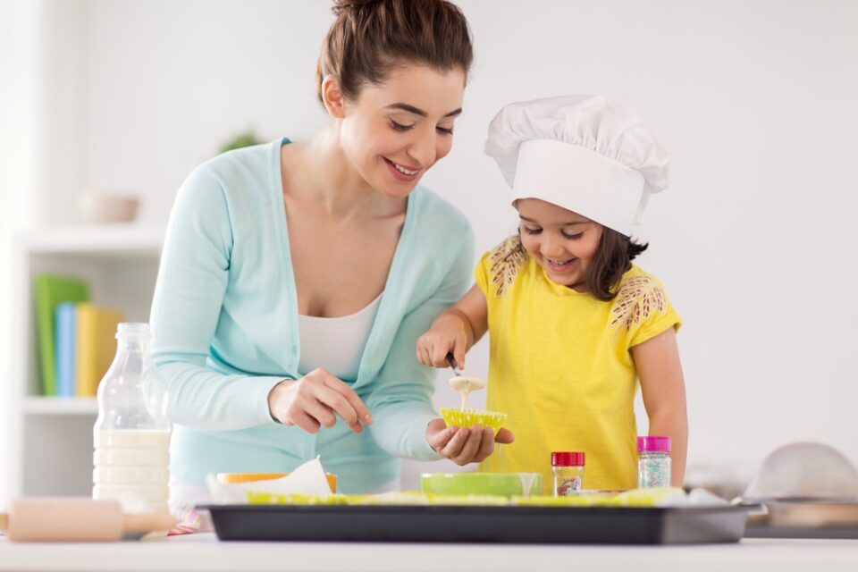 A mom and daughter baking cupcakes