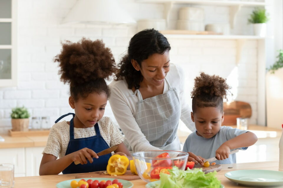 A mother and her two children prepare a salad