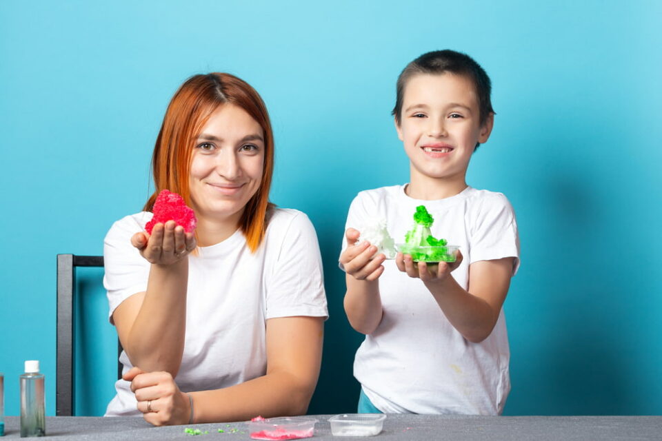 A mother and son hold up crystals they grew.