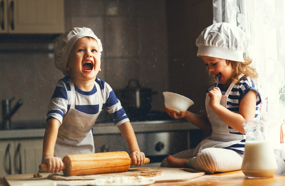 Young children having fun cooking at home.