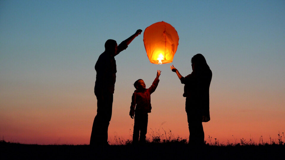 A family releases a paper lantern.