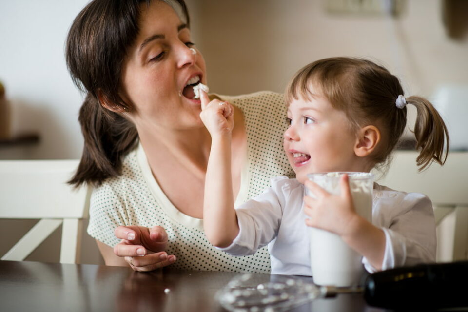 A mother and child tasting homemade whipped cream