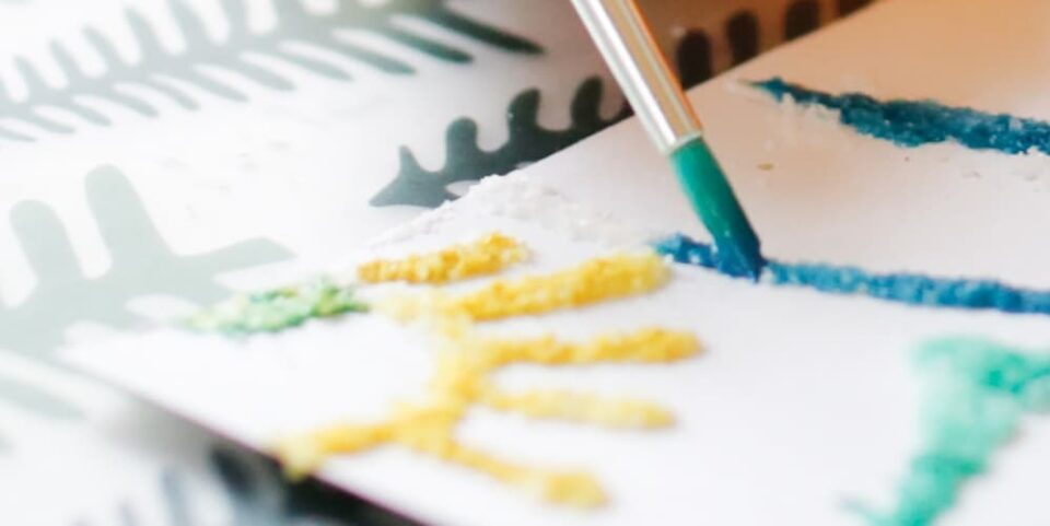 A child making 3D salt art with a paintbrush