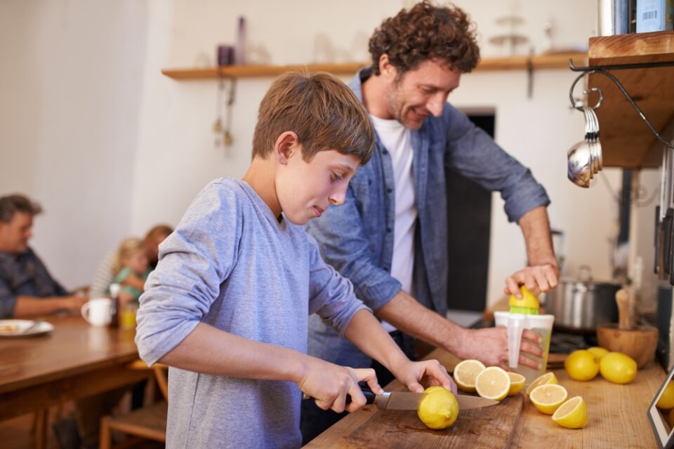 A father and son juicing lemons to make lemonade.
