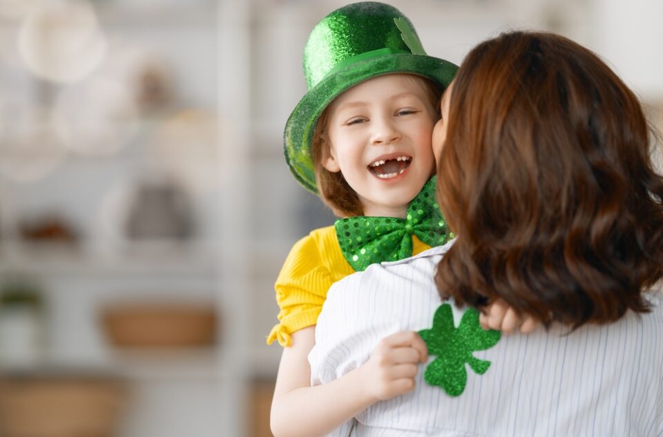 A mother and daughter hugging and celebrating St. Patrick’s Day.