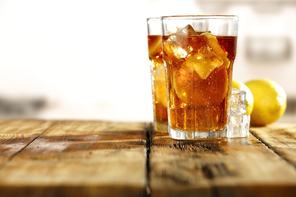 Two glasses of sweet tea on a wooden picnic table