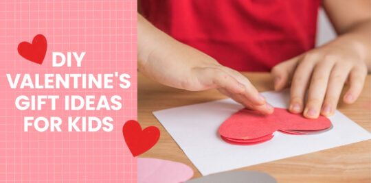 A child’s hands making a homemade Valentine’s Day card.