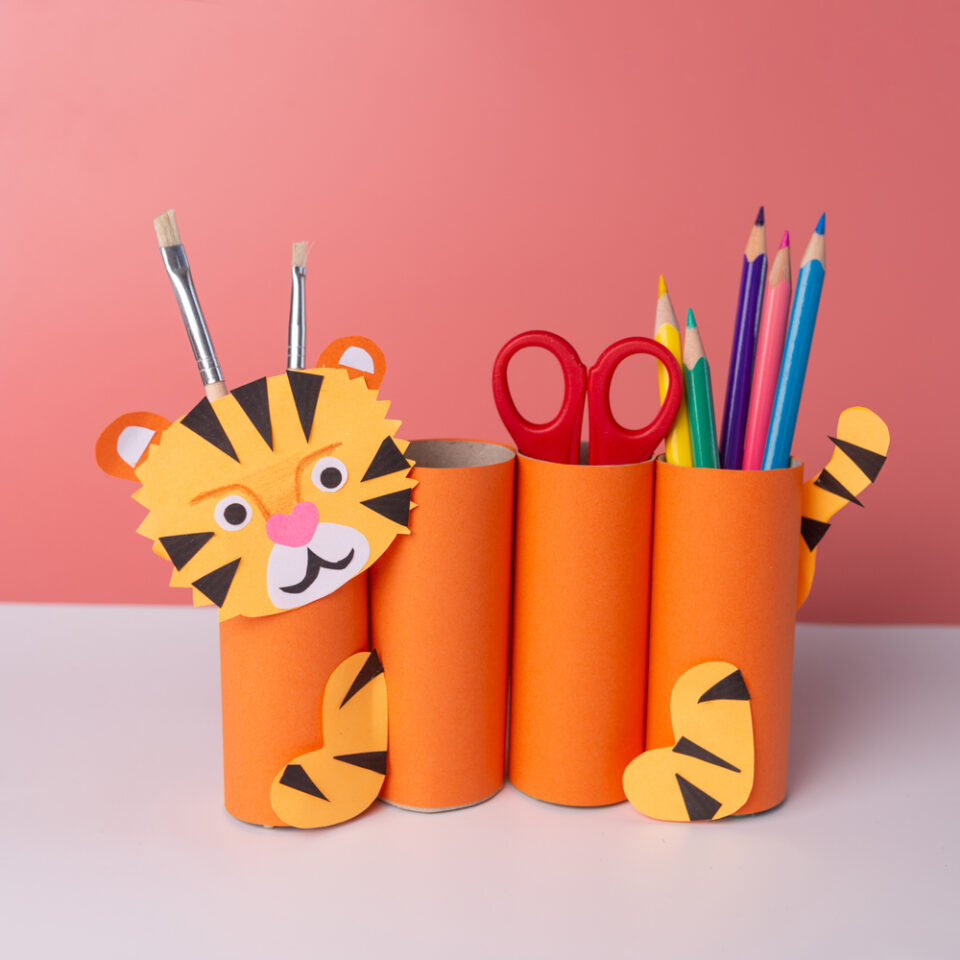 A DIY pencil holder decorated to look like a tiger sitting on a table