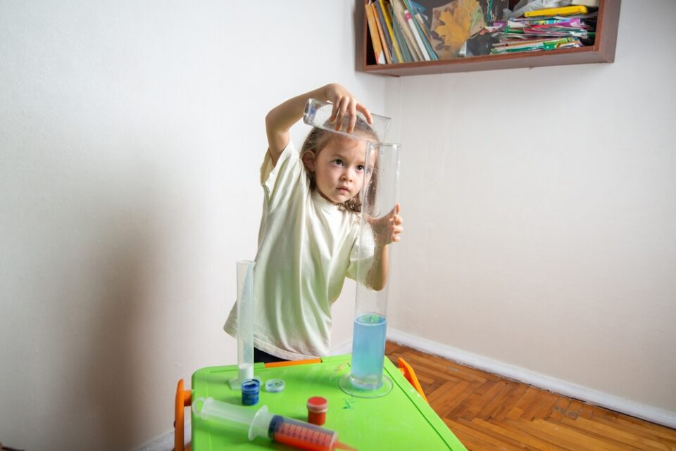 A young girl performing a science experiment at home