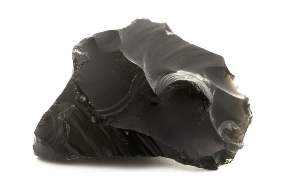 An obsidian shard on a white background.