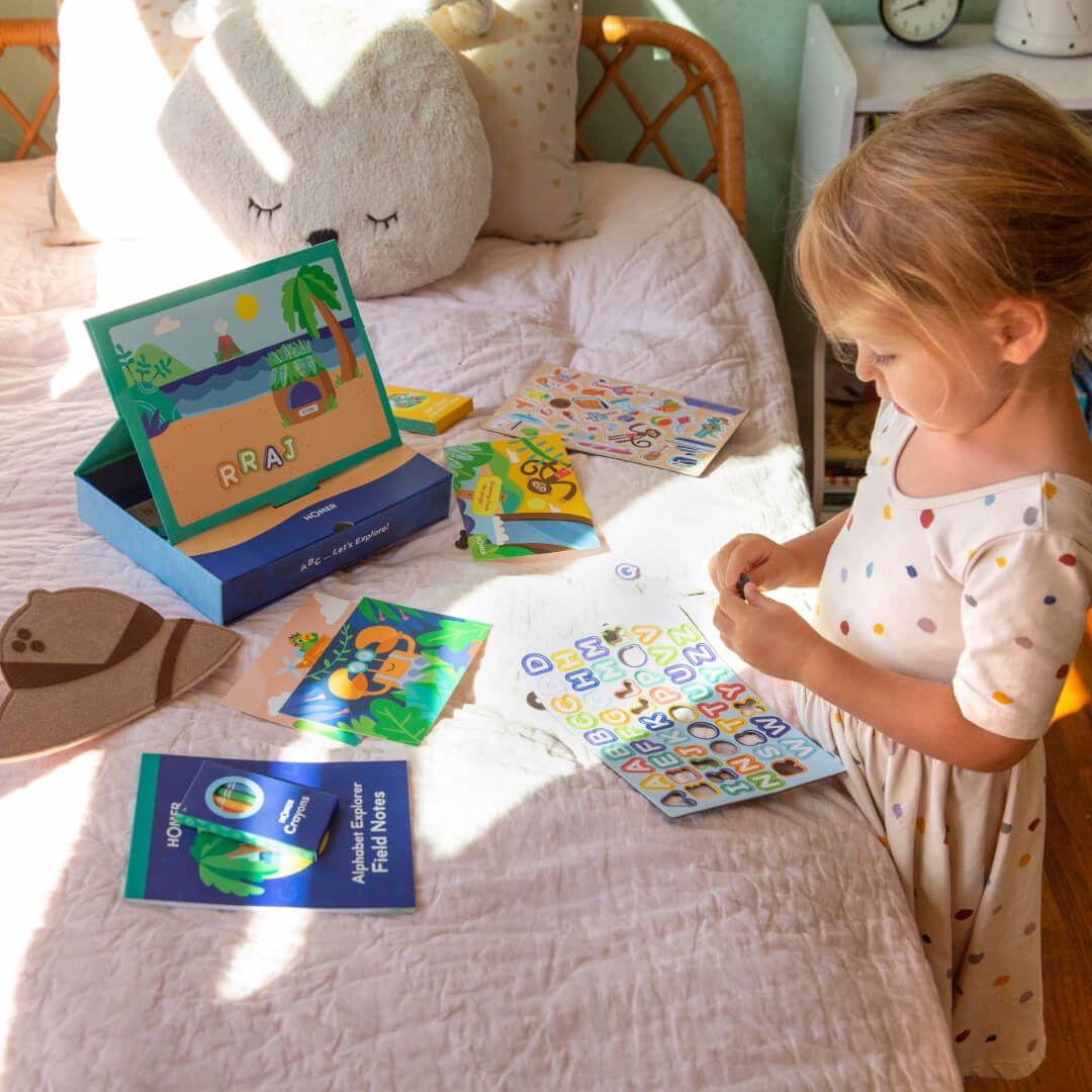 Kid playing with HOMER explore letters kit
