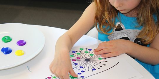 Child painting on a dandelion template