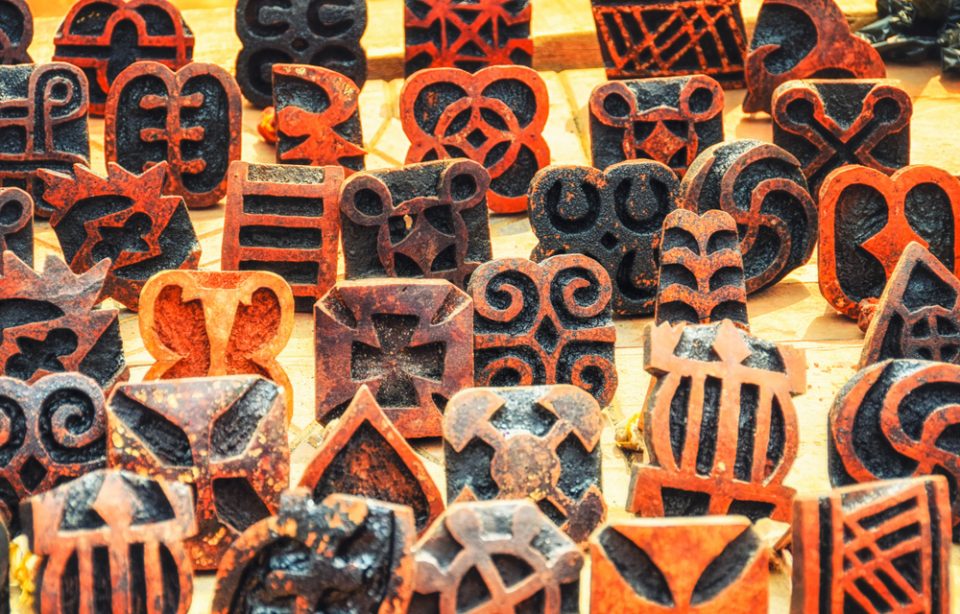 Adinkra stamps lined up on a table