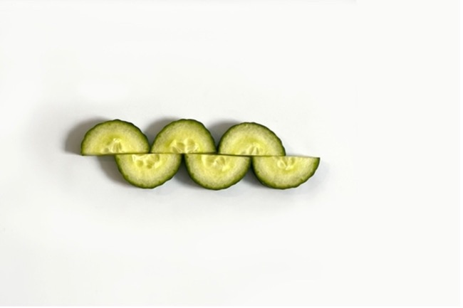 Six half cucumber slices arranged to look like an undulating snake